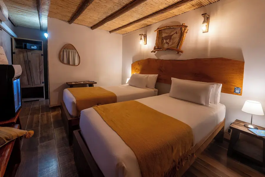 Quarto com duas camas, cabeceira de madeira maciça
